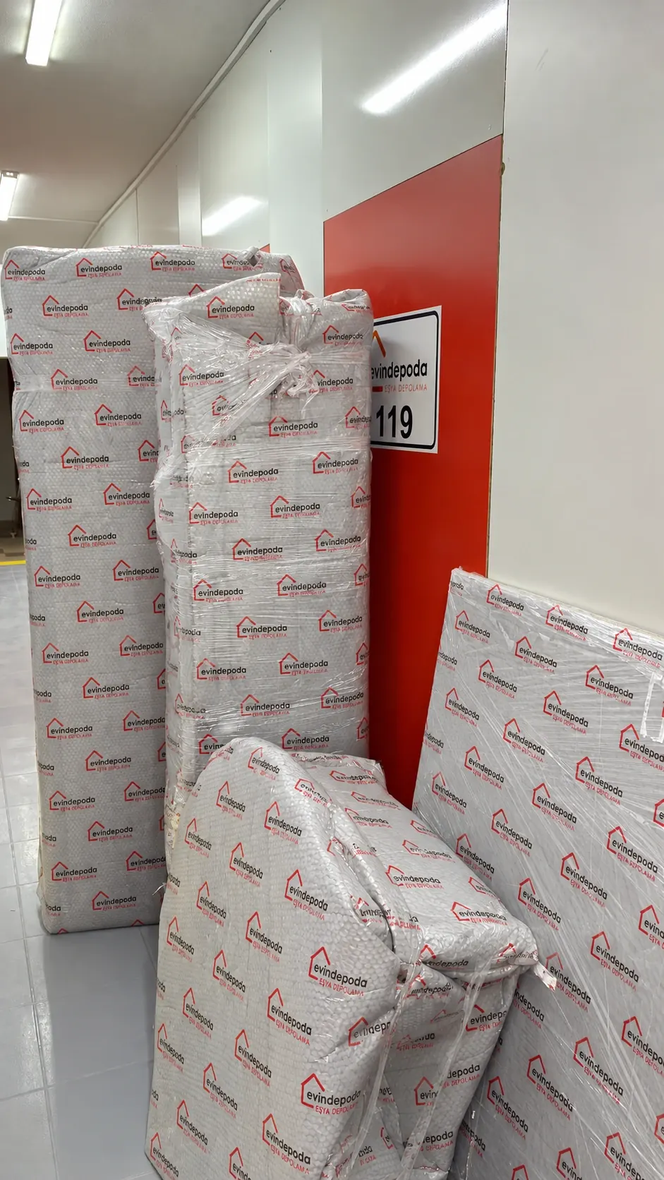 Logolu sargı malzemesiyle paketlenmiş eşyalar, 119 numaralı depo odasının önünde